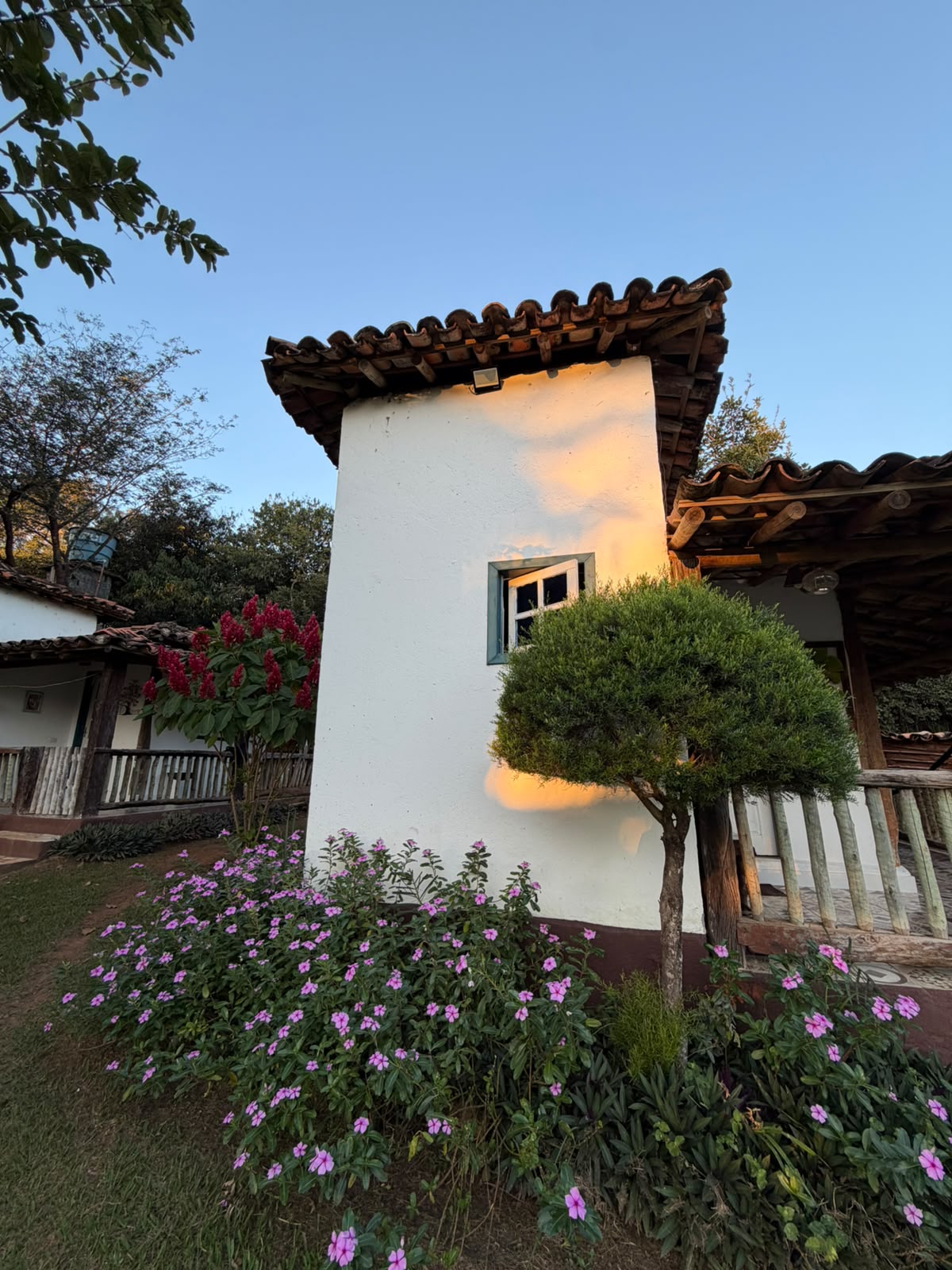 Fachada de um dos chalés cercada por flores