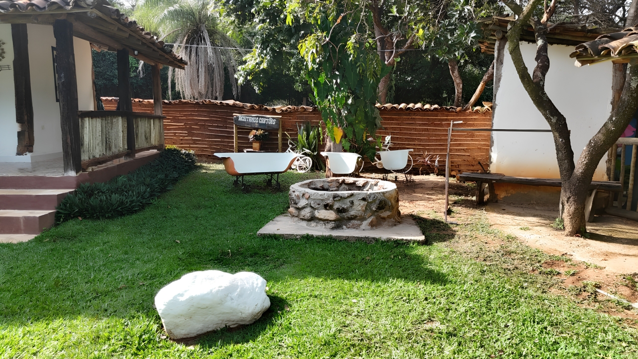 Área externa com fogão de chão e jardim da fazenda