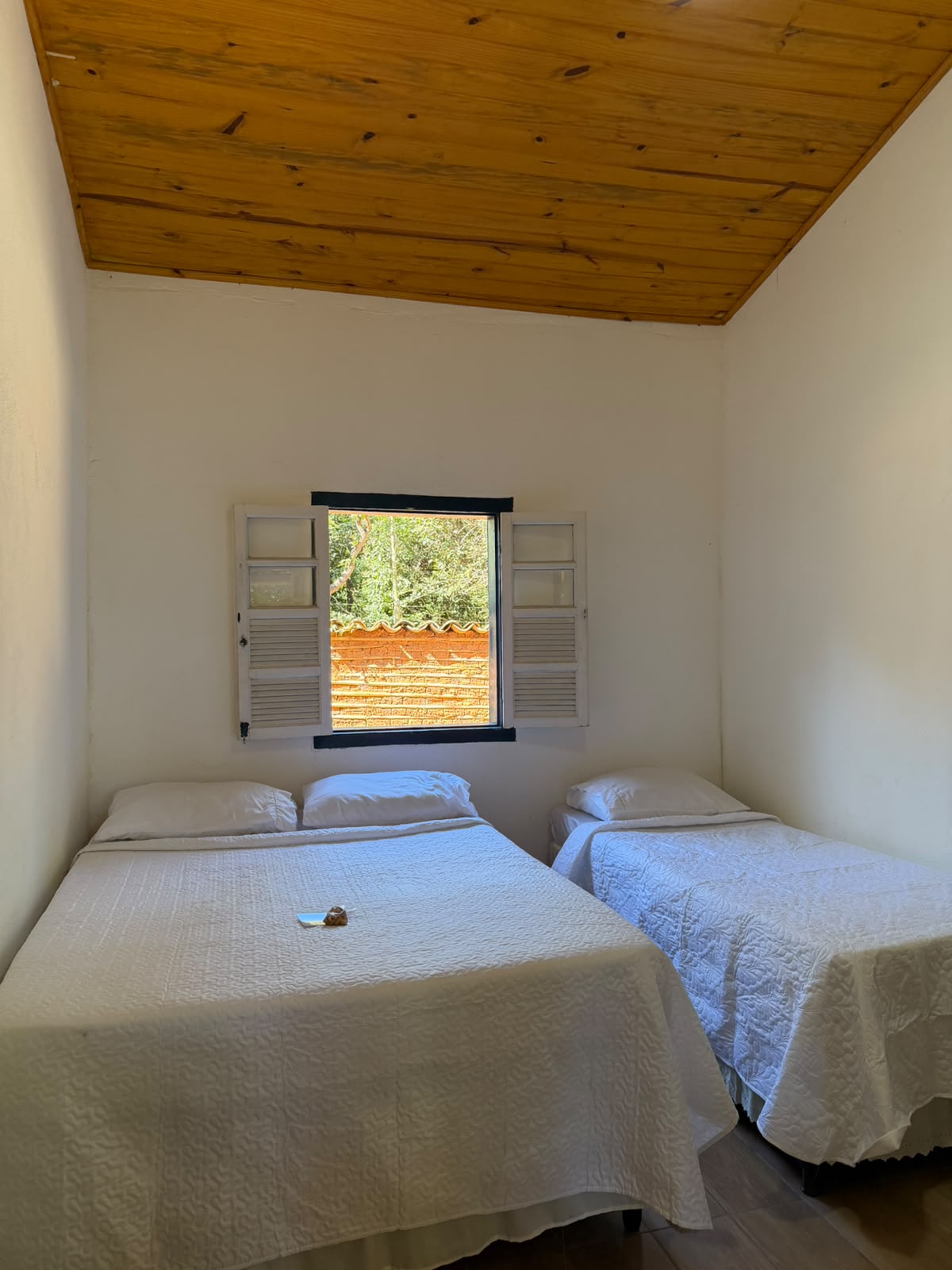 Quarto com cama de casal e solteiro, forro em madeira