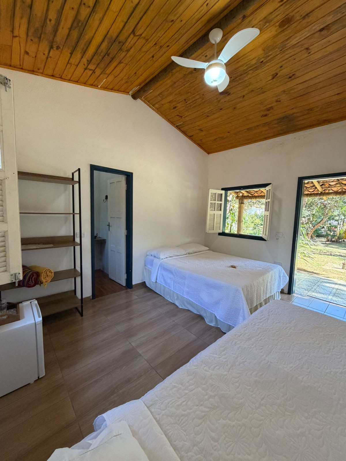 Quarto com frigobar e vista para a área da piscina