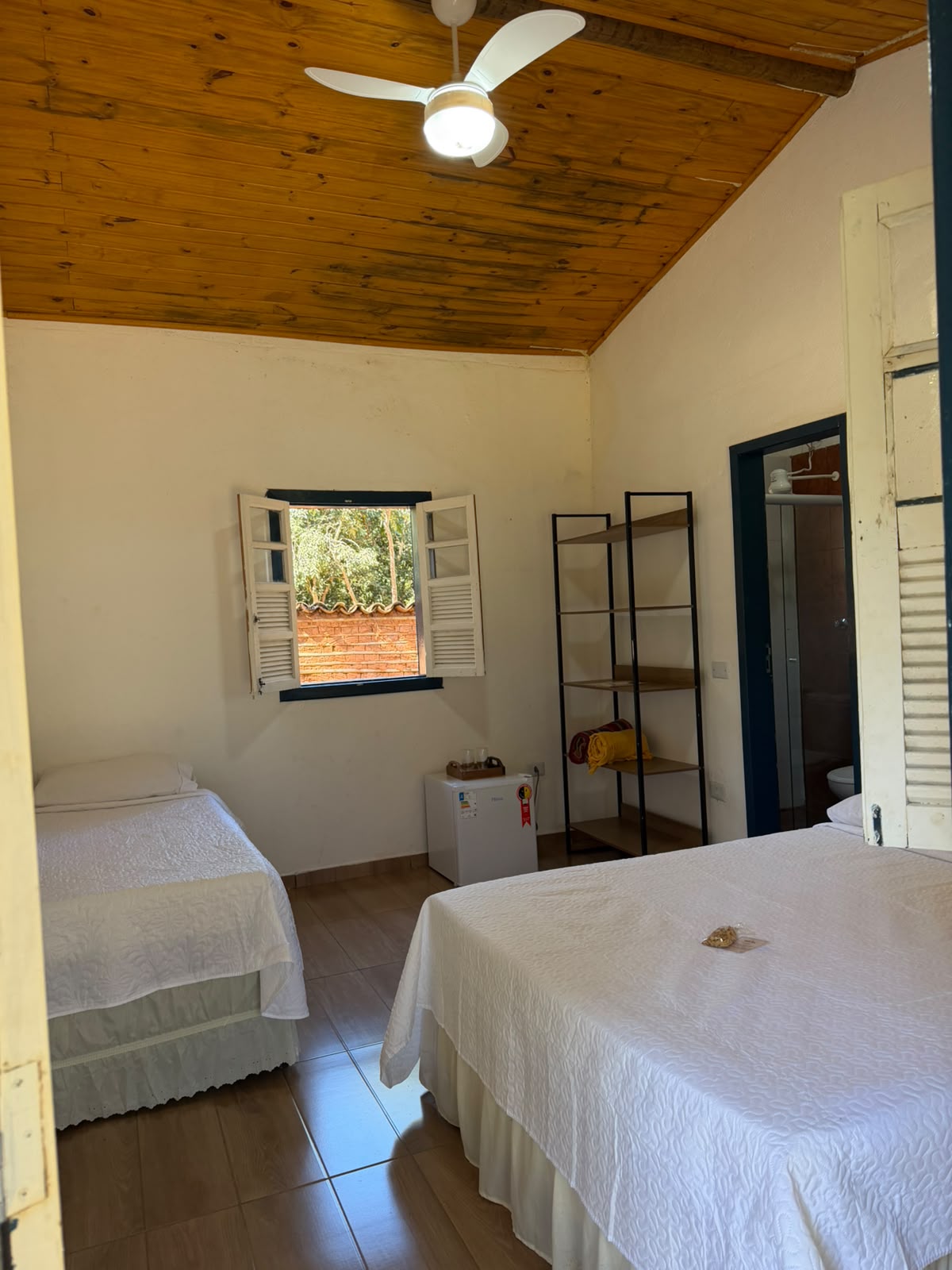 Quarto com janela de treliça e vista para o jardim